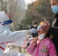 Un miembro del personal médico recolecta muestras de una niña para una prueba de la COVID-19, en la ciudad de Wuhan, 5 de marzo de 2020. Foto: AFP.