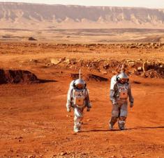 Un par de astronautas caminan vestidos con trajes espaciales durante una misión de entrenamiento para Marte en el cráter Ramón en el desierto de Negev en Israel.