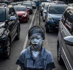 Un niño de 8 años mendiga en las calles de Depok, Indonesia. Aldi forma parte de un grupo conocido como "Manusia Silver" (hombres de plata) que recurren a este peligroso disfraz para atraer limosnas.