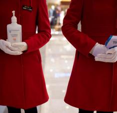 Empleados con un desinfectante y un termómetro en la entrada de un centro commercial, Wuhan, China, el 30 de marzo de 2020. Foto: Reuters