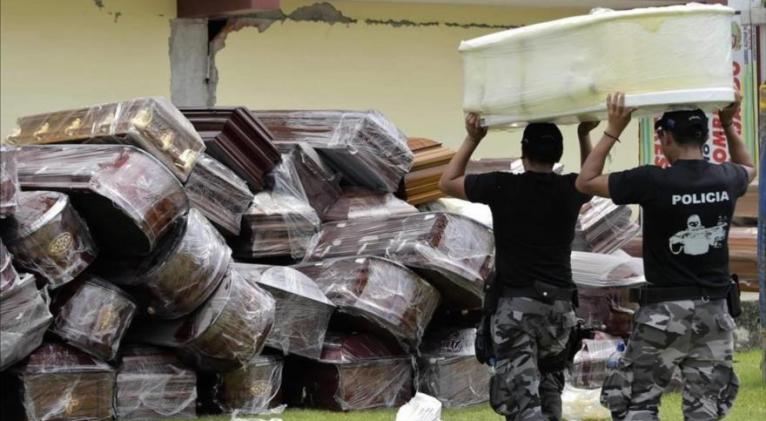 Agentes de policía apilan ataúdes en Pedernales, en Guayaquil, Ecuador, el April 7, 2020. Foto: AFP