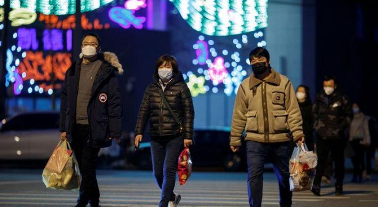 Personas con mascarillas frente a un centro comercial en Pekín, China, 11 marzo 2020. REUTERS/Thomas Peter