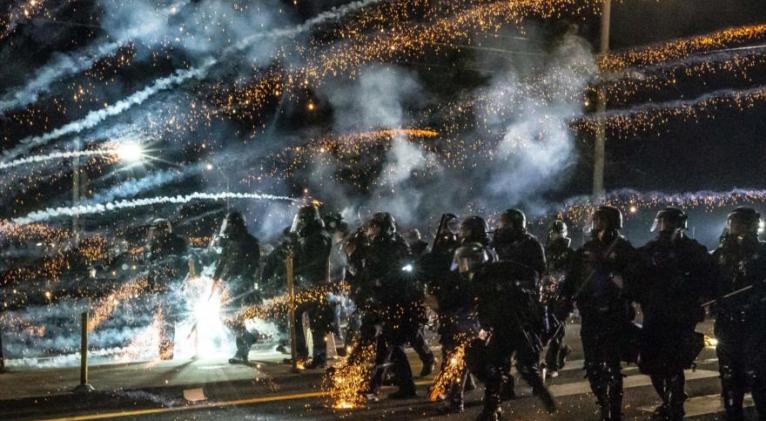 Los agentes del estado de Oregón, EE.UU., avanzan a través de gas lacrimógeno mientras dispersan una protesta antirracista, 5 de septiembre de 2020. Foto: AFP.