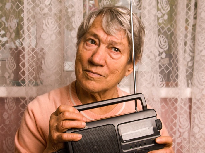 mujer mayor oyendo radio