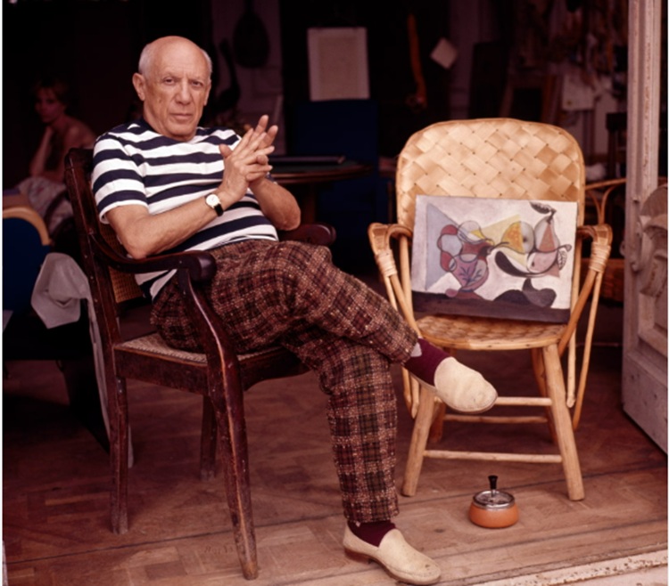 Pablo Picasso junto a una de sus obras