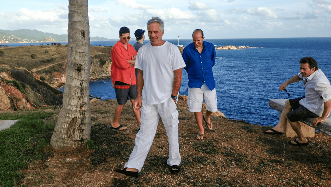 Foto publicada por el Departamento de Justicia de EE.UU. donde aparece Jeffrey Epstein vestido de blanco, Howard Lutnick, de azul, y tres hombres no identificados. RT