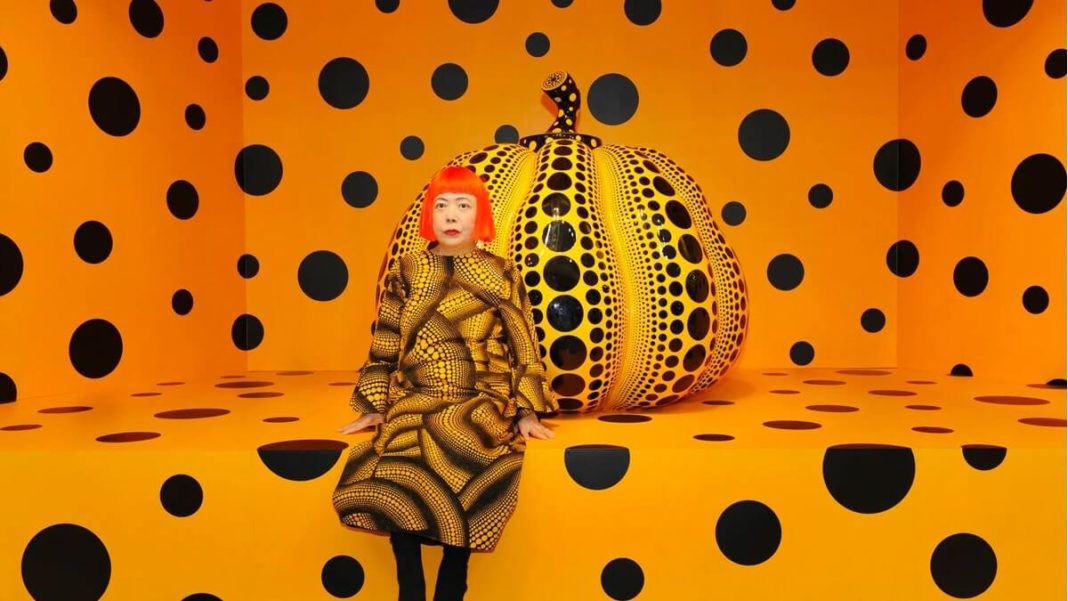 Yayoi Kusama rodeada de lunares, color intenso y una calabaza