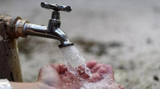 Mano de niño bajo llave de agua