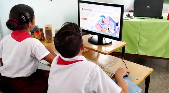 dos estudiantes frente a pantalla de PC