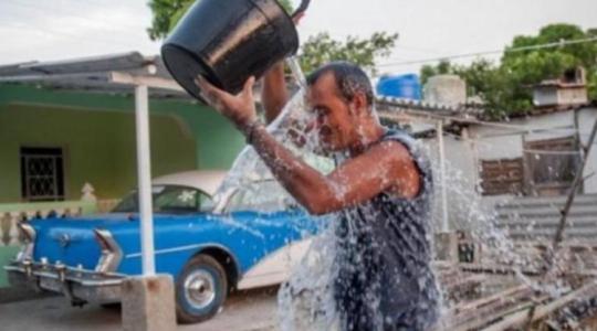 Cubano echándose cuba de agua en la cabeza por el calor