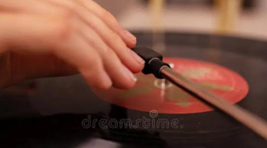 Mano accionando tocadiscos clásico con disco de vinilo